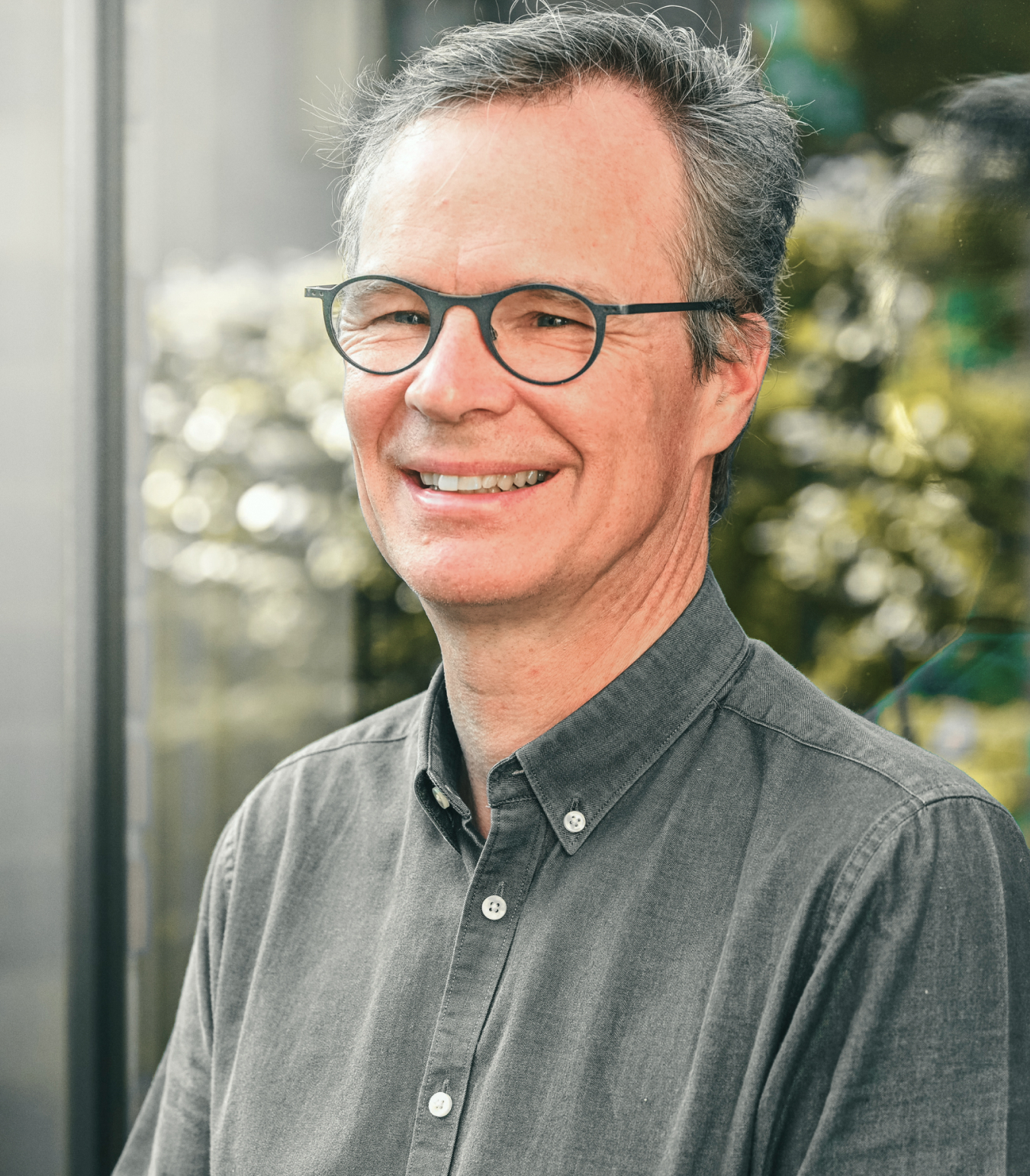 Portrait of Alain Jardinet in front of clear glass windows