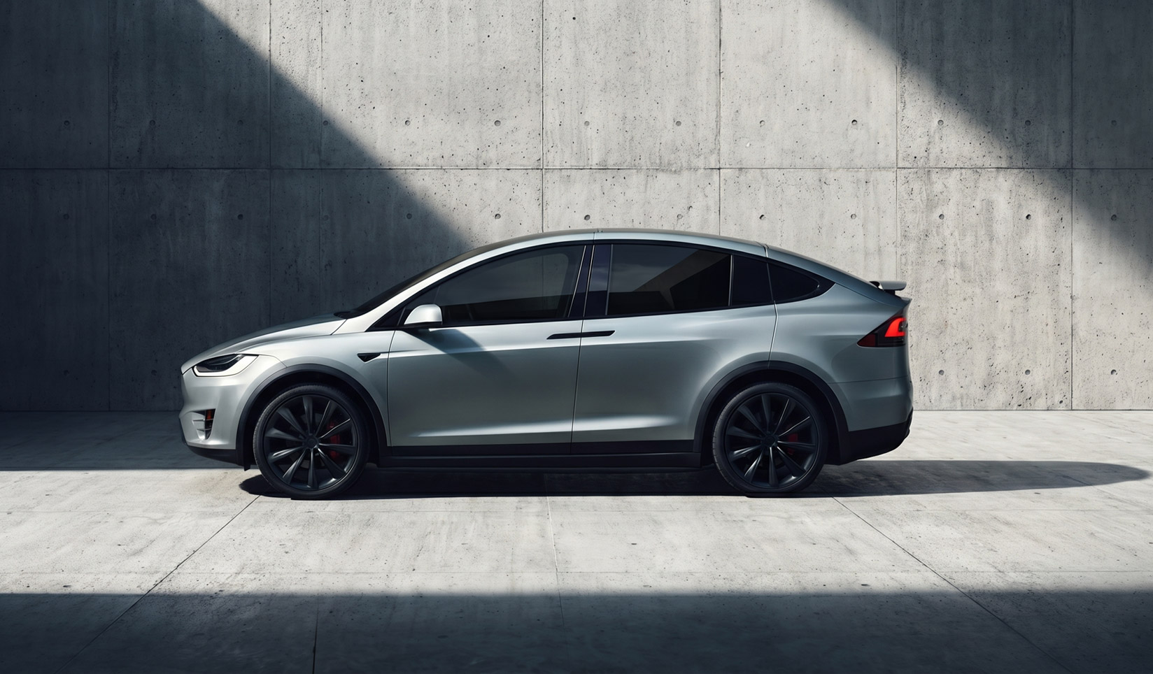 A sleek, modern car in a shaft of bright sunlight with darkly tinted windows.